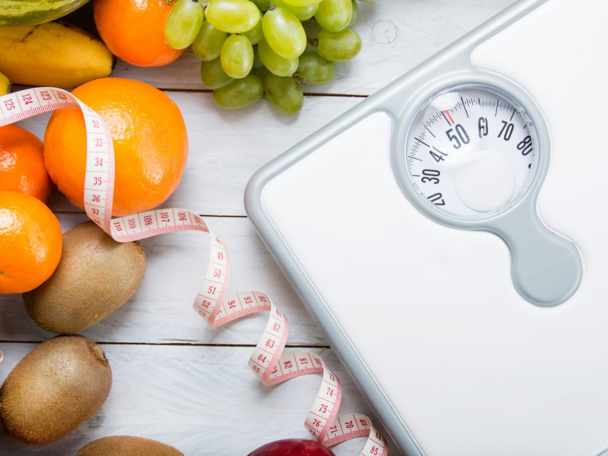 Fresh fruit and a scale representing sustainable weight management